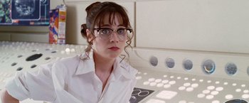 Movie still from “The Hitchhiker's Guide to the Galaxy” (2005), directed by Garth Jennings – A woman wearing glasses sitting in front of an oven; Close Up shot, Over the shoulder angle