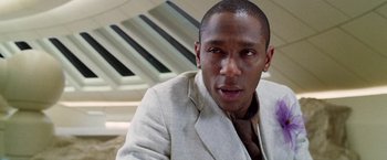 Movie still from “The Hitchhiker's Guide to the Galaxy” (2005), directed by Garth Jennings – A person wearing a suit and tie; Close Up shot, Over the shoulder angle