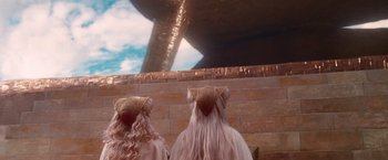 Movie still from “The Hitchhiker's Guide to the Galaxy” (2005), directed by Garth Jennings – Two women with long blonde hair wearing pink and gold headpieces; Wide shot, High angle