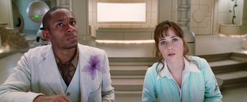 Movie still from “The Hitchhiker's Guide to the Galaxy” (2005), directed by Garth Jennings – A man and a woman sitting next to each other in front of a staircase; Close Up shot, Over the shoulder angle