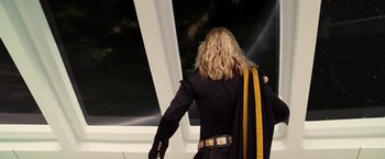 Movie still from “The Hitchhiker's Guide to the Galaxy” (2005), directed by Garth Jennings – A man with long blonde hair wearing a black jacket; Medium shot, Low angle