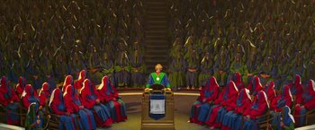 Movie still from “The Hitchhiker's Guide to the Galaxy” (2005), directed by Garth Jennings – A painting of a man sitting at a podium in front of a group of people; Extreme Wide shot, High angle