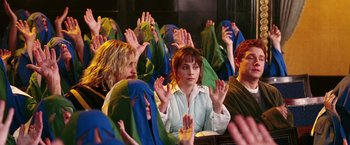 Movie still from “The Hitchhiker's Guide to the Galaxy” (2005), directed by Garth Jennings – A group of people in a room with their hands up; Medium shot, High angle