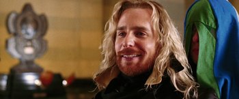 Movie still from “The Hitchhiker's Guide to the Galaxy” (2005), directed by Garth Jennings – A person with long blonde hair; Close Up shot, Over the shoulder angle