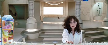 Movie still from “The Hitchhiker's Guide to the Galaxy” (2005), directed by Garth Jennings – A woman sitting at a table in a room; Medium shot, High angle