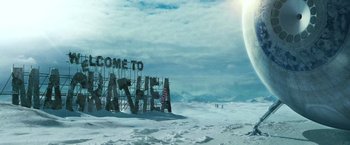 Movie still from “The Hitchhiker's Guide to the Galaxy” (2005), directed by Garth Jennings – A sign that says welcome to basheba on a snowy field; Extreme Wide shot, Low angle