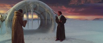 Movie still from “The Hitchhiker's Guide to the Galaxy” (2005), directed by Garth Jennings – A man standing in the snow next to an ice sculpture; Wide shot, Low angle