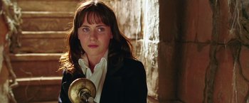 Movie still from “The Hitchhiker's Guide to the Galaxy” (2005), directed by Garth Jennings – A woman in a black jacket and white shirt holding an object; Close Up shot, Low angle