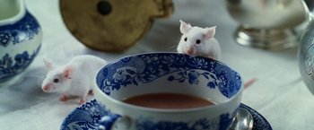 Movie still from “The Hitchhiker's Guide to the Galaxy” (2005), directed by Garth Jennings – A white mouse sitting on top of a blue and white cup; Extreme Close Up shot, High angle