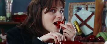 Movie still from “The Hitchhiker's Guide to the Galaxy” (2005), directed by Garth Jennings – A woman is eating a piece of fruit; Close Up shot, Over the shoulder angle