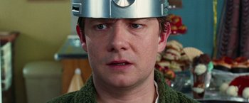 Movie still from “The Hitchhiker's Guide to the Galaxy” (2005), directed by Garth Jennings – A person wearing a metal helmet; Close Up shot, Over the shoulder angle