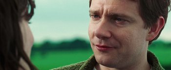 Movie still from “The Hitchhiker's Guide to the Galaxy” (2005), directed by Garth Jennings – A man's face in a green jacket; Close Up shot, Over the shoulder angle