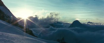 Movie still from “The Hitchhiker's Guide to the Galaxy” (2005), directed by Garth Jennings – The sun is shining through the clouds on the mountain; Extreme Wide shot, Low angle