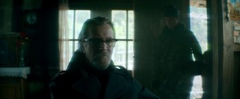 Movie still from “The Hitman's Bodyguard” (2017), directed by Patrick Hughes – A man with a beard wearing glasses and a black jacket; Medium shot, Over the shoulder angle