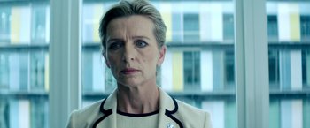 Movie still from “The Hitman's Bodyguard” (2017), directed by Patrick Hughes – An older woman in a white jacket looking at the camera; Close Up shot, Over the shoulder angle