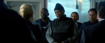 Movie still from “The Hitman's Bodyguard” (2017), directed by Patrick Hughes – A group of men standing next to each other in a room; Medium shot, Over the shoulder angle