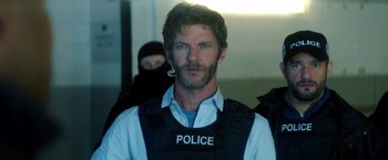 Movie still from “The Hitman's Bodyguard” (2017), directed by Patrick Hughes – A man in a police uniform with a pipe in his mouth; Close Up shot, Over the shoulder angle