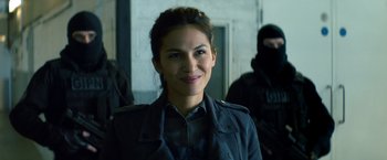 Movie still from “The Hitman's Bodyguard” (2017), directed by Patrick Hughes – A woman wearing a black jacket and smiling for the camera; Close Up shot, Over the shoulder angle
