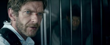 Movie still from “The Hitman's Bodyguard” (2017), directed by Patrick Hughes – A person behind a fence; Close Up shot, Over the shoulder angle