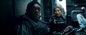 Movie still from “The Hitman's Bodyguard” (2017), directed by Patrick Hughes – A man and a woman holding a gun in front of a building; Close Up shot, Over the shoulder angle