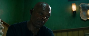 Movie still from “The Hitman's Bodyguard” (2017), directed by Patrick Hughes – A bald man with headphones in his ears; Close Up shot, Low angle