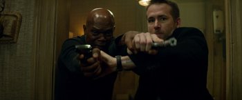 Movie still from “The Hitman's Bodyguard” (2017), directed by Patrick Hughes – Two men are holding guns in a room; Close Up shot, Low angle