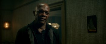 Movie still from “The Hitman's Bodyguard” (2017), directed by Patrick Hughes – A man with a black shirt is standing in a room; Close Up shot, Low angle