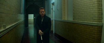 Movie still from “The Hitman's Bodyguard” (2017), directed by Patrick Hughes – A man in a black jacket holding a white stick; Medium shot, High angle