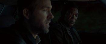 Movie still from “The Hitman's Bodyguard” (2017), directed by Patrick Hughes – Two men sitting in a car in the dark; Close Up shot, Over the shoulder angle