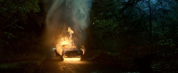 Movie still from “The Hitman's Bodyguard” (2017), directed by Patrick Hughes – A car on fire on the side of the road; Extreme Wide shot, High angle