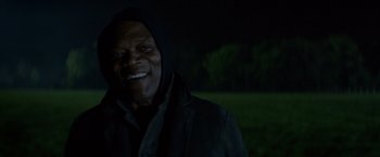 Movie still from “The Hitman's Bodyguard” (2017), directed by Patrick Hughes – A man smiling for the camera in the dark; Close Up shot, Over the shoulder angle