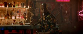 Movie still from “The Hitman's Bodyguard” (2017), directed by Patrick Hughes – An older man sitting at a counter in a bar; Medium shot, Over the shoulder angle