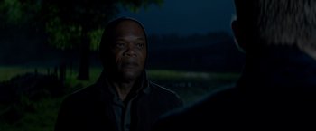 Movie still from “The Hitman's Bodyguard” (2017), directed by Patrick Hughes – A man in a hooded jacket is looking at the camera; Close Up shot, Over the shoulder angle