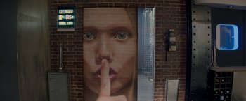 Movie still from “The Hitman's Bodyguard” (2017), directed by Patrick Hughes – A woman with her finger on her mouth in front of a brick wall; Extreme Close Up shot, Low angle