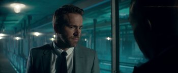 Movie still from “The Hitman's Bodyguard” (2017), directed by Patrick Hughes – A person wearing a suit and tie; Close Up shot, Over the shoulder angle