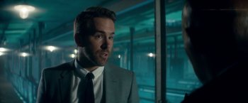 Movie still from “The Hitman's Bodyguard” (2017), directed by Patrick Hughes – A person wearing a suit and tie; Close Up shot, Over the shoulder angle