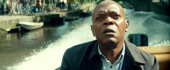 Movie still from “The Hitman's Bodyguard” (2017), directed by Patrick Hughes – A man in a black jacket and white shirt looking up at the sky; Close Up shot, Low angle
