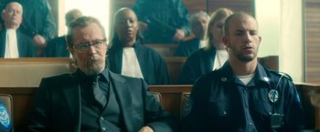 Movie still from “The Hitman's Bodyguard” (2017), directed by Patrick Hughes – A group of people sitting in a court room; Medium shot, Over the shoulder angle