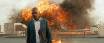Movie still from “The Hitman's Bodyguard” (2017), directed by Patrick Hughes – A man standing in front of a fire explosion; Medium shot, Low angle