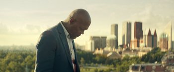 Movie still from “The Hitman's Bodyguard” (2017), directed by Patrick Hughes – A man in a suit and tie looking down at the ground; Medium shot, Low angle