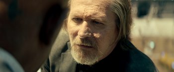 Movie still from “The Hitman's Bodyguard” (2017), directed by Patrick Hughes – An older man with a beard and mustache; Close Up shot, Over the shoulder angle