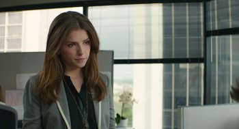 Movie still from “The Hollars” (2016), directed by John Krasinski – A woman standing in front of a window in an office; Medium shot, Over the shoulder angle