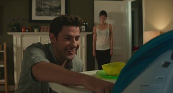 Movie still from “The Hollars” (2016), directed by John Krasinski – A man and a woman are looking at a laptop computer; Medium shot, Over the shoulder angle