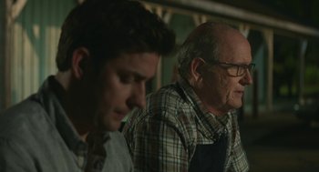 Movie still from “The Hollars” (2016), directed by John Krasinski – Two men sitting next to each other in a room; Close Up shot, Over the shoulder angle