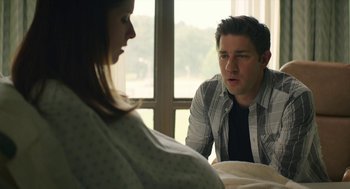 Movie still from “The Hollars” (2016), directed by John Krasinski – A man and a woman sitting in front of a window; Medium shot, Over the shoulder angle