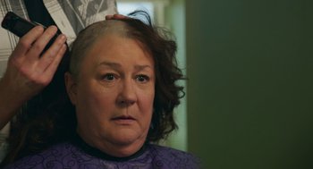 Movie still from “The Hollars” (2016), directed by John Krasinski – An older woman is getting her head shaved; Close Up shot, Over the shoulder angle