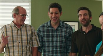 Movie still from “The Hollars” (2016), directed by John Krasinski – A group of men standing next to each other in a room; Medium shot, Over the shoulder angle