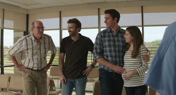 Movie still from “The Hollars” (2016), directed by John Krasinski – A group of men and a woman standing next to each other; Medium shot, Over the shoulder angle
