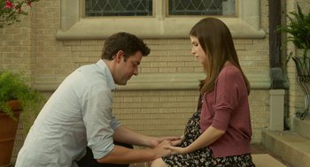 Movie still from “The Hollars” (2016), directed by John Krasinski – A man and a pregnant woman touching their hands; Medium shot, High angle