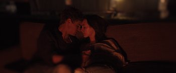 Movie still from “The Host” (2013), directed by Andrew Niccol – A man and a woman sitting on top of a couch; Medium shot, High angle